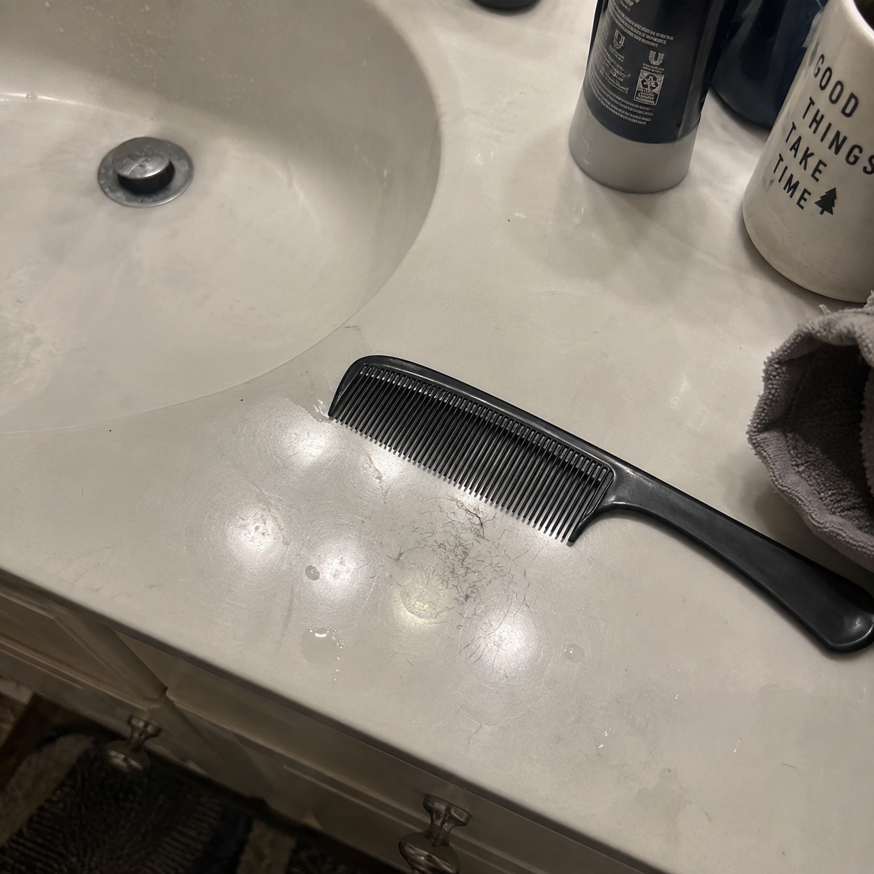 Shed hairs on the sink beside a comb